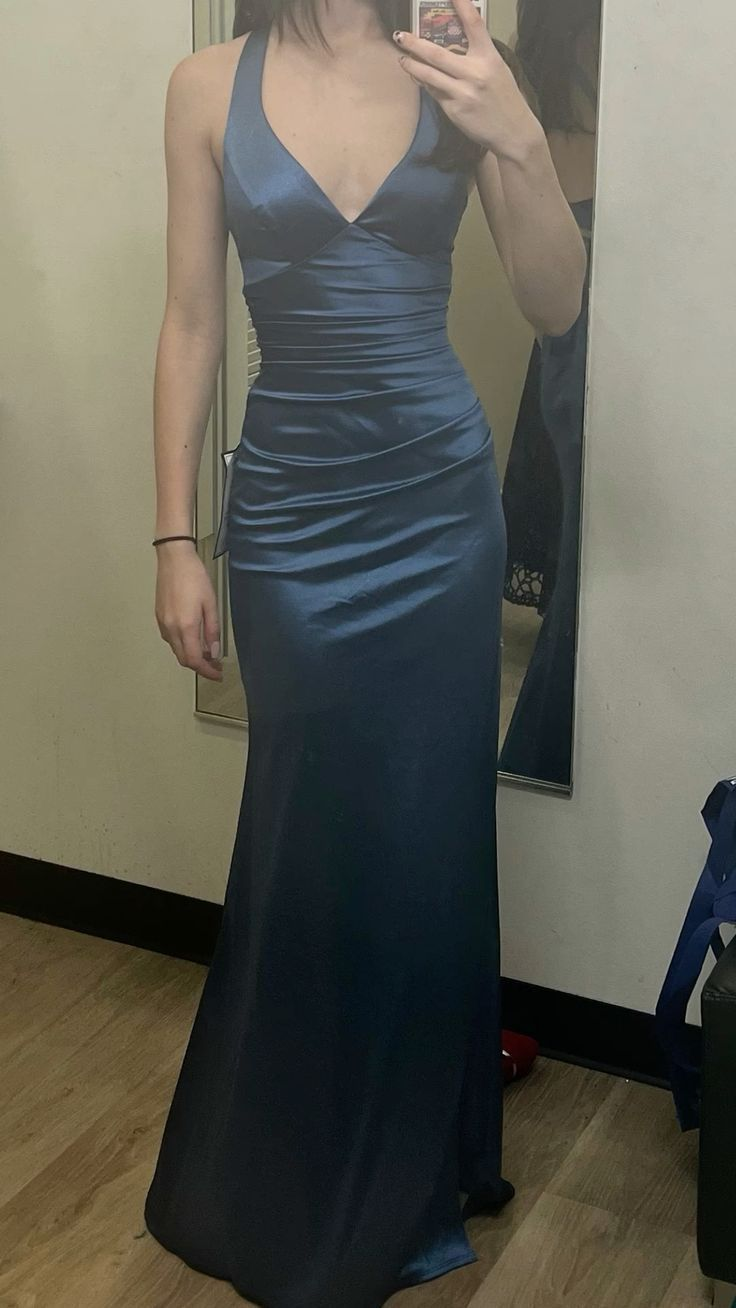 Vestido de fiesta de satén verde con corte sirena y cuello halter.