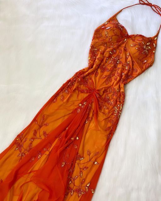 Vestido de fiesta único con tirantes finos en color naranja y cuentas, ideal para bodas formales.
