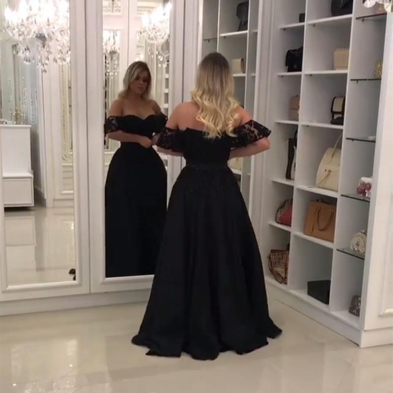 Elegante vestido de fiesta de encaje negro con hombros descubiertos y abertura en la pierna