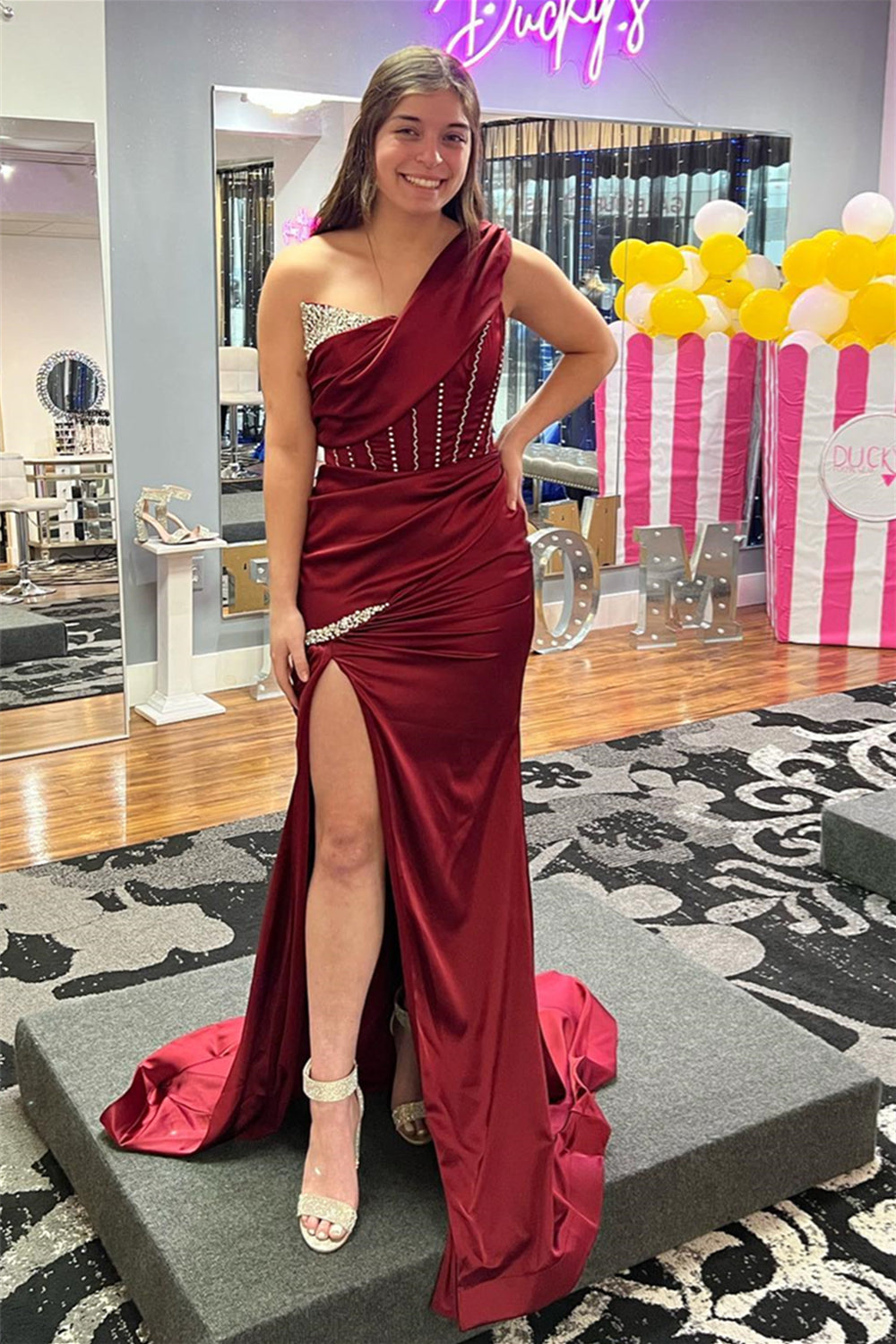 Vestido de fiesta largo de satén con cuentas y hombros descubiertos en color burdeos