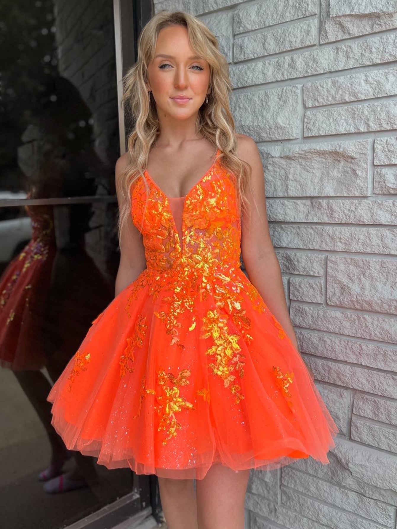 Vestido de fiesta corto con escote en V y apliques en color naranja, corte A, para fiesta de bienvenida.