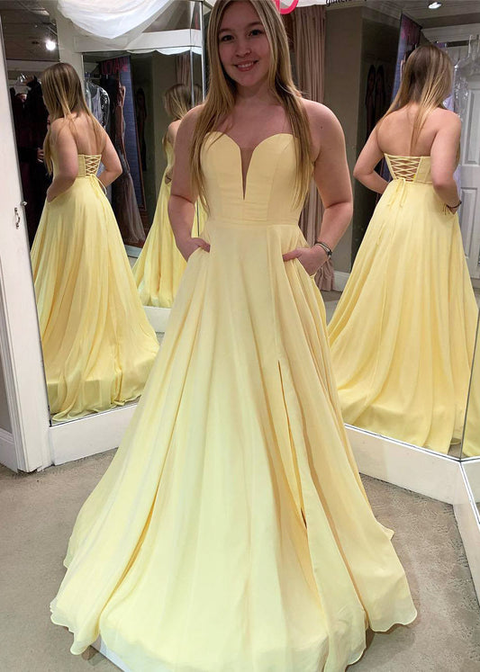 Vestido de fiesta largo amarillo sencillo con bolsillos y espalda con cordones.