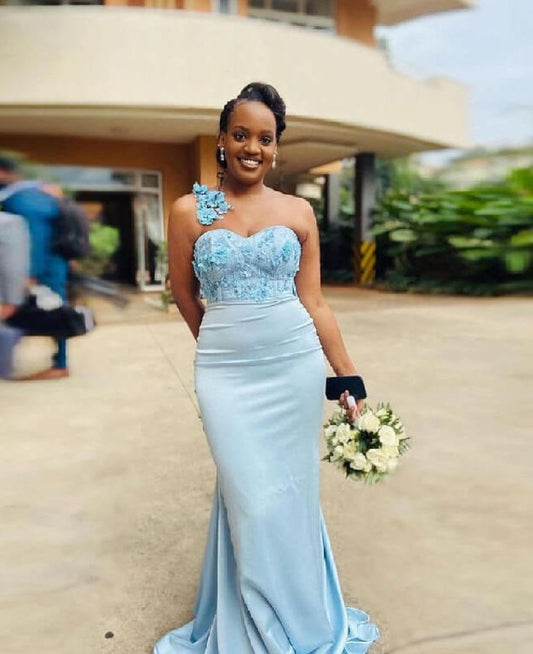 Vestido de dama de honor largo de sirena con un solo hombro en azul bebé, con apliques negros y espalda descubierta.