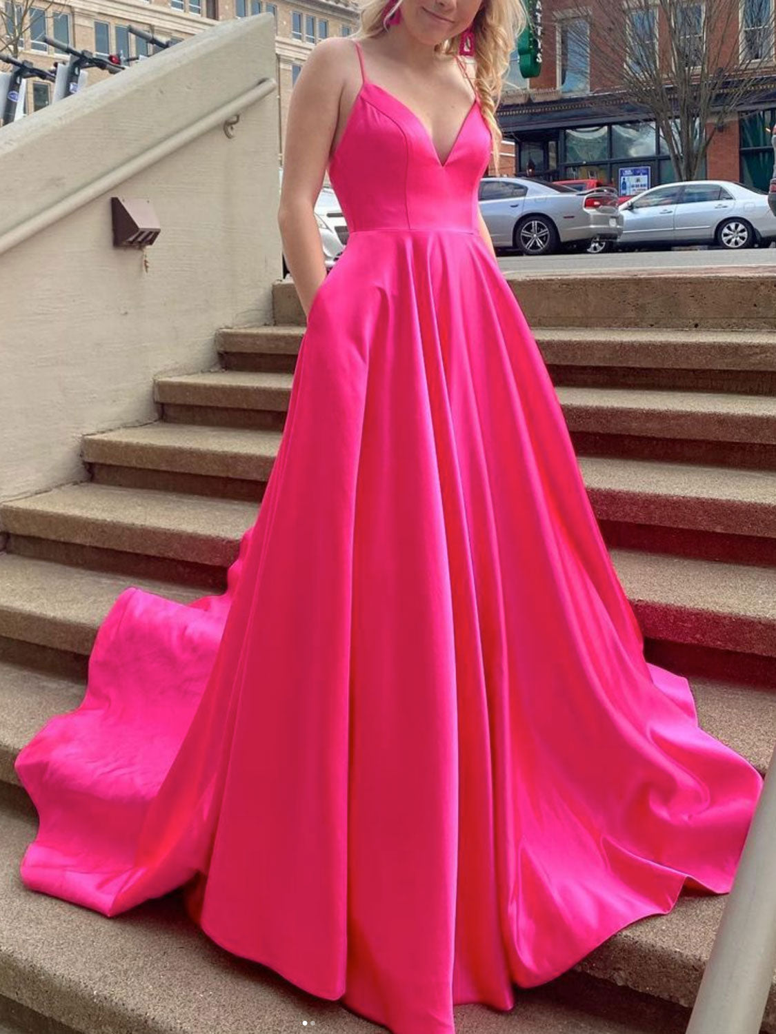Vestido de fiesta largo de satén fucsia con escote en V y bolsillos.
