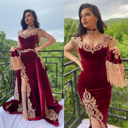 Vestido de noche largo rojo vino con apliques florales dorados de terciopelo y abertura.