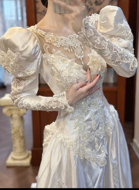 Vestido de novia vintage blanco perla con escote redondo, satén, manga larga, apliques de encaje con cuentas, espalda descubierta y cola ED02213