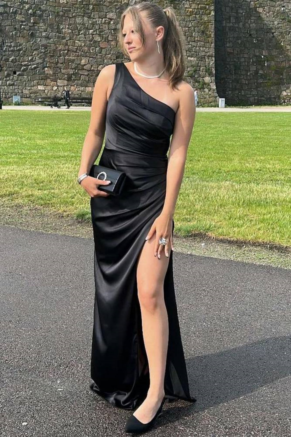 Vestido de fiesta largo de satén negro con corte sirena y un hombro al descubierto con abertura alta