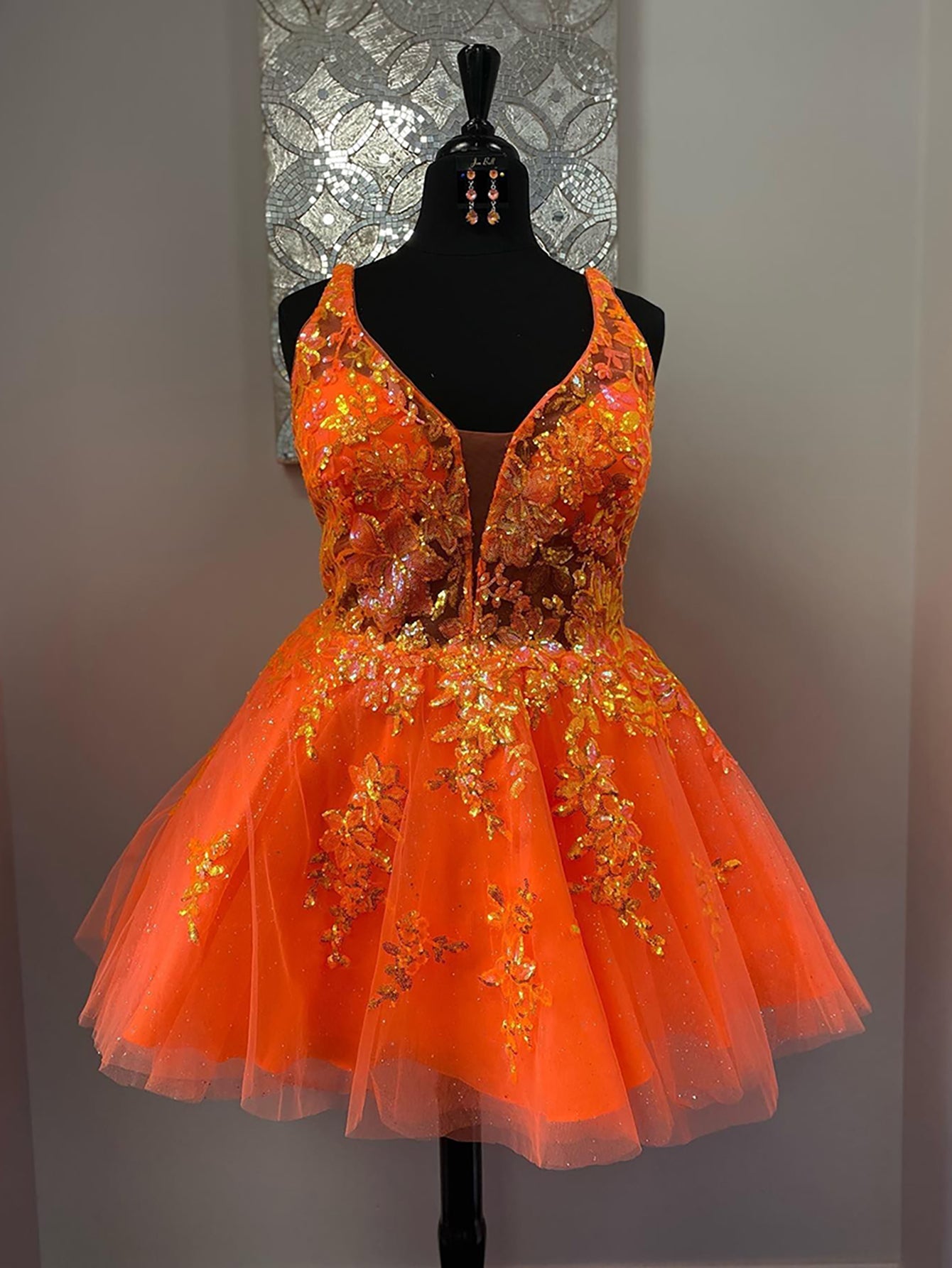 Vestido de fiesta corto con escote en V y apliques en color naranja, corte A, para fiesta de bienvenida.
