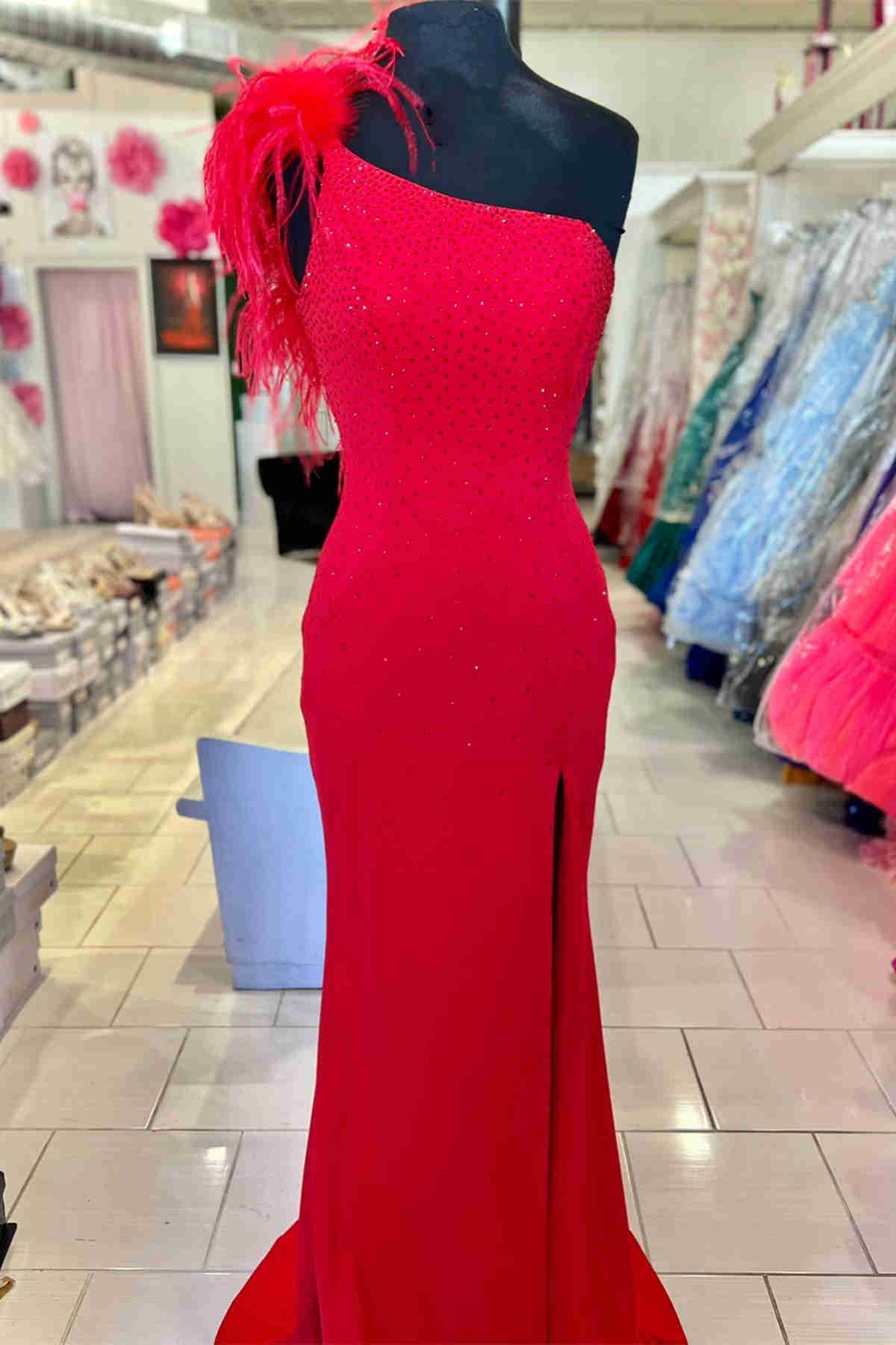 Vestido formal largo rosa intenso con un solo hombro, abertura en la pierna y plumas